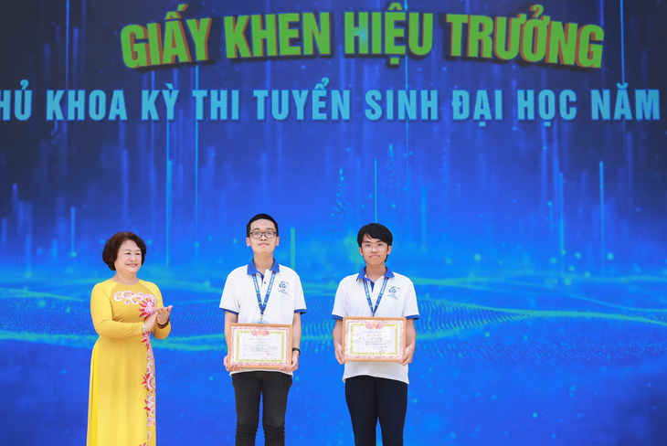 PGS.TS Nguyễn Hoàng Tú Anh vinh danh và trao giấy khen của hiệu trưởng cho hai thủ khoa kỳ tuyển sinh đại học năm 2023 - Ảnh TRƯƠNG DŨNG