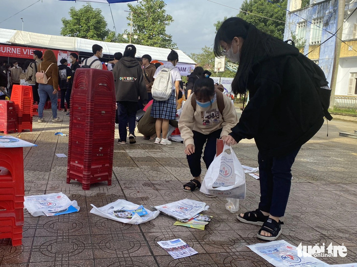 Hai bạn học sinh nán lại sau chương trình tư vấn tuyển sinh - hướng nghiệp ở Huế để nhặt rác, tờ rơi - Ảnh: TẤN VŨ