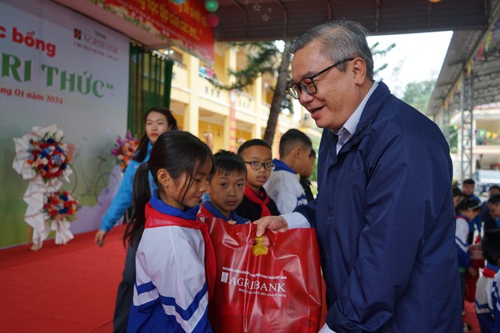 Phó tổng Biên tập Báo Tuổi Trẻ Đinh Minh Trung trao quà cho học sinh Hàm Yên - Ảnh: VŨ TUẤN