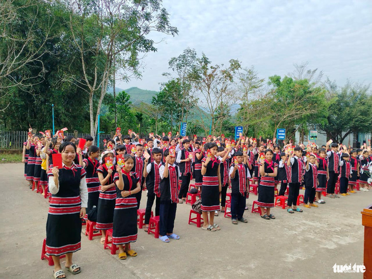 Nhiều bạn khoe bao lì xì trong trang phục thổ cẩm truyền thống trong ngày chào cờ - Ảnh: CLB