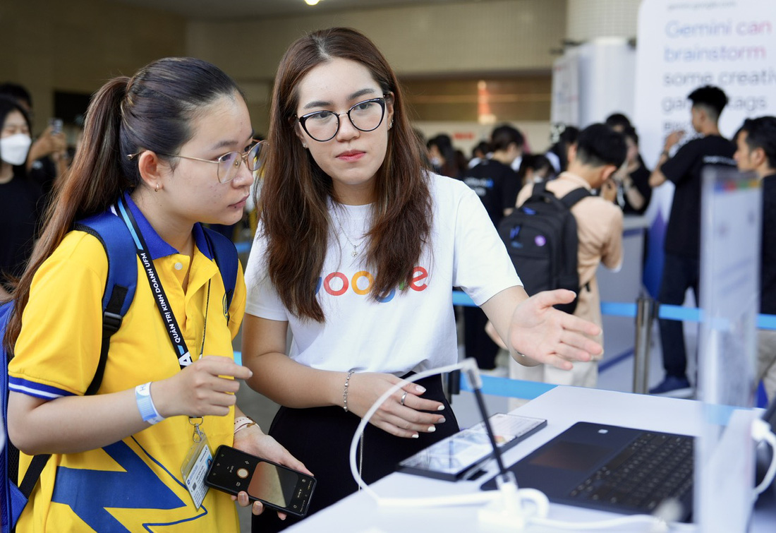 Nhân viên của Google tư vấn cho khách tham quan sáng 10-5 tại AI Day- Ảnh: HỮU HẠNH