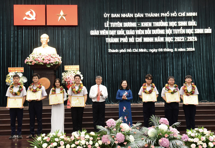 Bà Nguyễn Thị Lệ và ông Nguyễn Văn Hiếu trao bằng khen cho các em học sinh đoạt giải quốc tế, quốc gia - Ảnh: DUYÊN PHAN