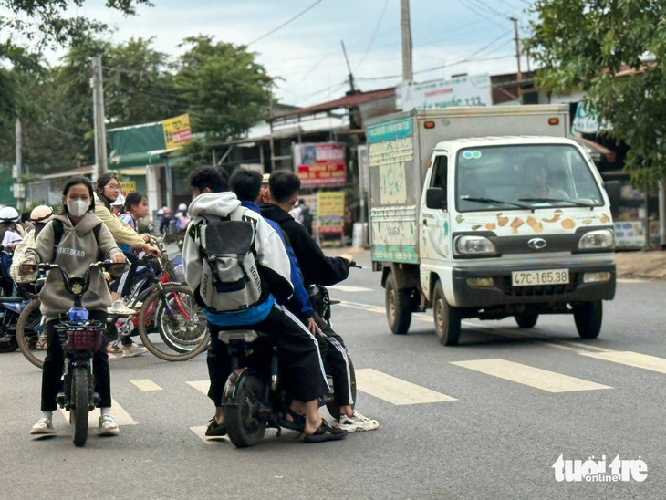 Vẫn chở ba, không mũ bảo hiểm phóng nhanh trước cổng trường - Ảnh 2.