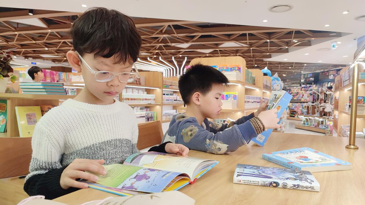 Bé Nguyễn Khánh Kiệt (7 tuổi) say sưa ngồi đọc sách. “Con rất thích được đi nhà sách, bởi vì ở đây có nhiều truyện con thích đọc”, Khánh Kiệt nói.