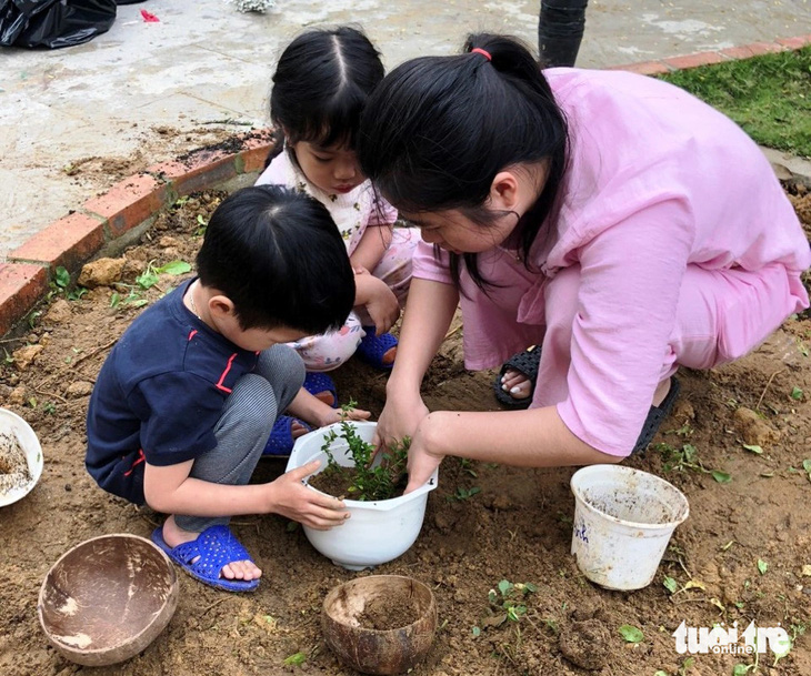 Các bạn nhỏ cùng cô giáo tại Trường mầm non Lâm Tỳ Ni trồng cây con có rễ là quà ngày 8-3 của phụ huynh gửi tặng nhà trường - Ảnh: NHẬT LINH