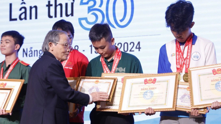 Võ Văn Thành (bìa phải) nhận huy chương và bằng khen của BTC kỳ thi Olympic toán học vừa qua - Ảnh: NVCC