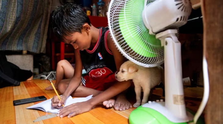 Một học sinh tại thủ đô Manila, Philippines đang học bài tại nhà ngày 26-4 sau thông báo đóng cửa trường học vì nắng nóng - Ảnh: REUTERS