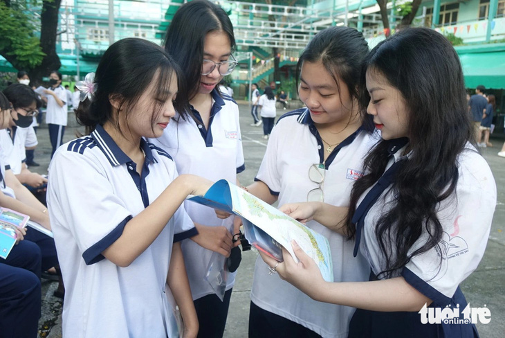 Thí sinh trao đổi bài trước giờ thi tổ hợp tại điểm thi Trường THCS Hà Huy Tập, quận Bình Thạnh, TP.HCM - Ảnh: NHƯ HÙNG